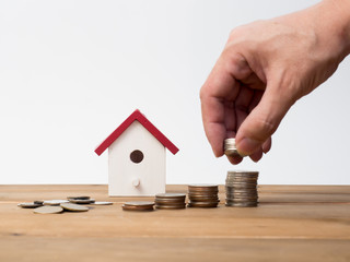 Money coins stack growing with red house on wood background. Business growth investment and financial concept ideas.Real estate investment. House and coins on table.Save money with stack coin.