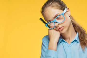 Beautiful young woman in glasses on a yellow background