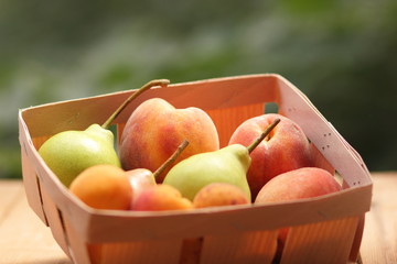 Pears and peaches in a wooden basket