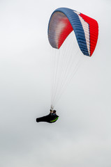 Colorful hang glider/paraglider against the blue sky