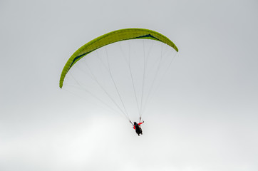 Colorful hang glider/paraglider against the blue sky