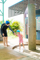 kid take a bath at swimming pool with mother