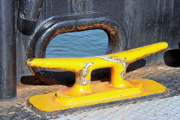 Empty yellow ship's bollard.