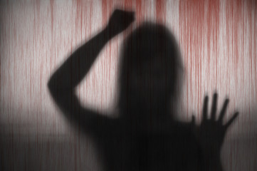 Horror woman behind hitting the matte blood stain glass in blurry hand and body figure abstraction