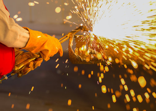 Asian worker cutting steel pipe by using metal torch and install roadside fence