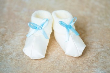 Baby booties with blue ribbons. Waiting for the boy.