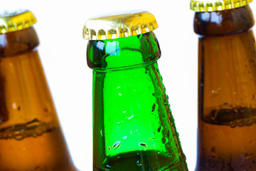 Necks of bottles with lids. Water droplets on the glass. Close up.