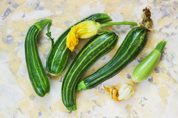 Fresh zucchini on wicker mat on Light background