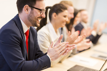 Group of business people clapping their hands at the meeting