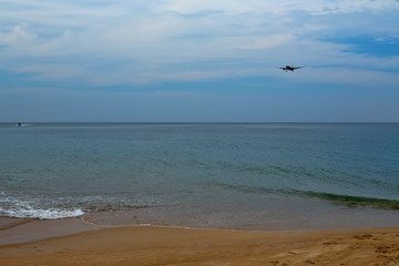 Plane comes in to land on a tropical beach