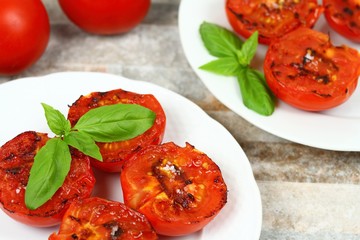 Grilled tomatoes with salt on plate.