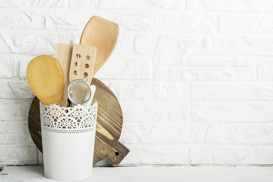 Kitchen tools, olive cutting board on a kitchen shelf against a white brick wall. selective focus