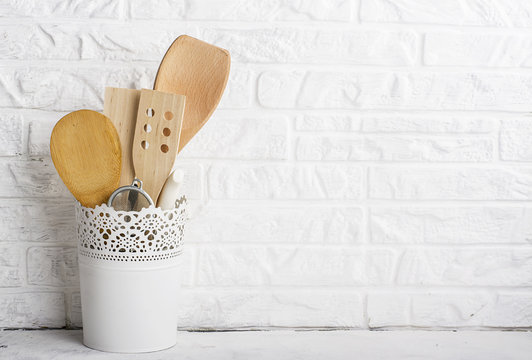 Kitchen tools, olive cutting board on a kitchen shelf against a white brick wall. selective focus