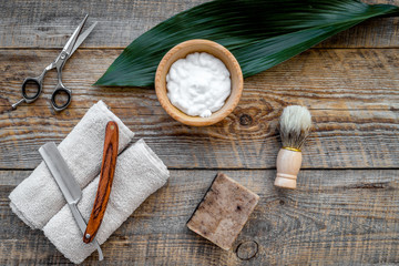 Fototapeta na wymiar Barber workplace. Shaving brush, razor, foam, sciccors on wooden table background top view