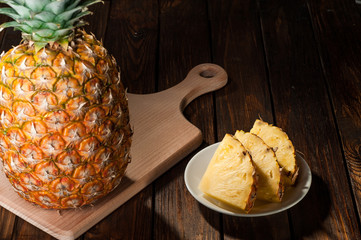 slices of a pineapple on dark wooden background