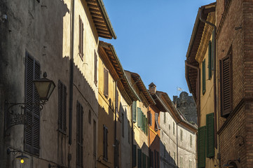 MONTALCINO, TUSCANY/ITALY: OCTOBER 31, 2016:   Narrow street in historic center of Montalcino town, Val d'Orcia, Tuscany, Italy. The town takes its name from a variety of oak tree  