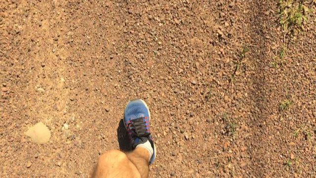 Punto di vista ragazzo che corre alla sera su strada di campagna
