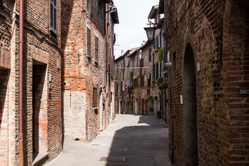 Lane of a village of Umbria, with wooden bow doors on facades of ancient brick houses