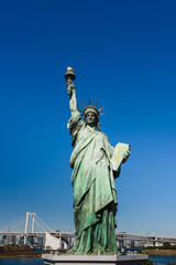 Statue of liberty against the sky. Statue of Liberty and Rainbow bridge, located at Odaiba Tokyo.
