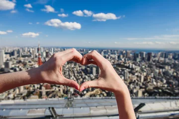 Poster Female hands In form of heart against Tokyo Tower with skyline in Tokyo Japan. © o_lypa