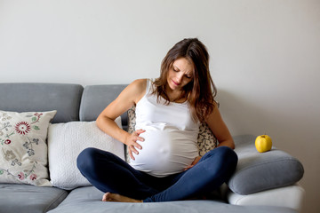 Young pregnant woman, having painful contraction, starting labor