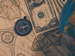 Fototapeta na wymiar Antique pirate world map and new modern compass concept travel around the world with one dollar money of United States of America, vintage vintage