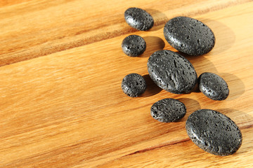 Fototapeta na wymiar A spa background image consisting of lava beads on a wood. 