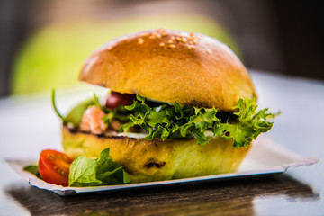 Sandwich hamburger with and mix of vegetables.