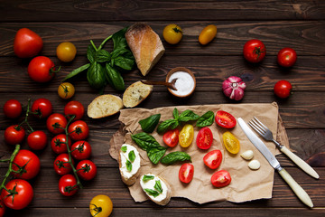 Naklejka na ściany i meble Italian Bruschetta with cheese, basil and tomatoes. Cooking. Top view.