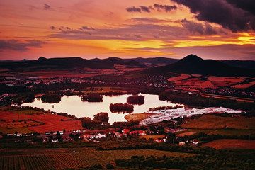 View to Zernosecke jezero lake and Lovos hill from Radobyl hill  in CHKO Ceske Stredohori tourist area after sunset  in czech summer landscape