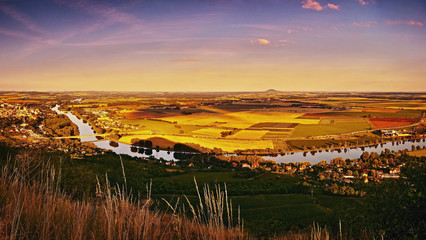 Sunset panoramatic view from Radobyl hill to river Labe, golden fields, hill Rip and cities...