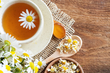 cup of herbal chamomile tea with fresh daisy flowers on wooden background. doctor treatment and prevention of immune concept, medicine - folk, alternative, complementary, traditional medicine 