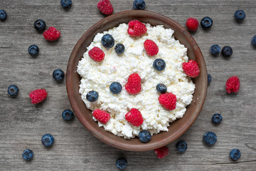 cottage cheese with fresh raspberries and blueberries in a bowl for healthy breakfast
