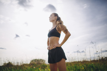 Fitness sport girl runner taking break after jogging outdoors