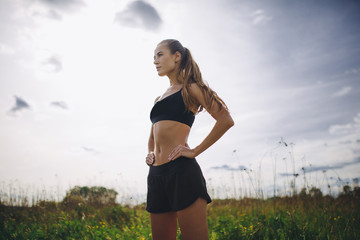 Fitness sport girl runner taking break after jogging outdoors