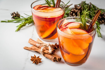 Christmas, Thanksgiving drinks. Autumn, winter cocktail grog, hot sangria, mulled wine - apple, rosemary, cinnamon, anise. On white marble table. With cones, rosemary. Copy space