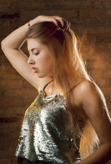 Fototapeta premium Fashion portrait of pretty woman posing in dark studio with mixed light