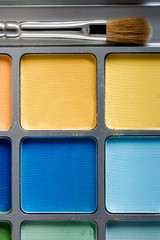 professional cosmetics. Palette of multicolored eye shadow and makeup brush, top view