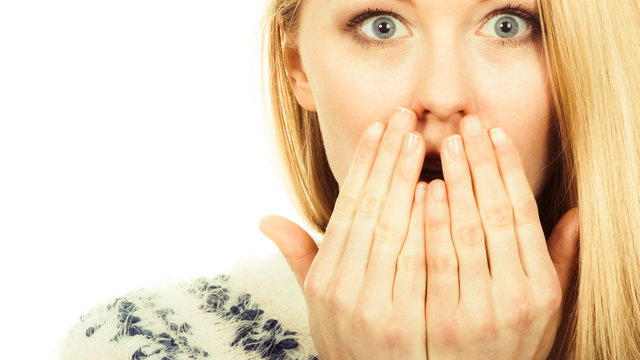 Shocked young woman covering mouth with hand
