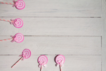 Lollipops sweets, pink woman concept. Candy, top view flat lay on white wood background. Sweet , lollipop, candy, mock up