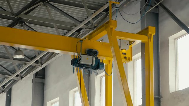 Overhead crane moves in large workshop