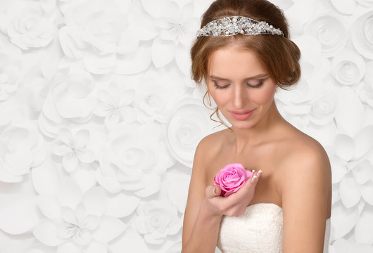 the bride in a necklace from pearls looks at a flower rose