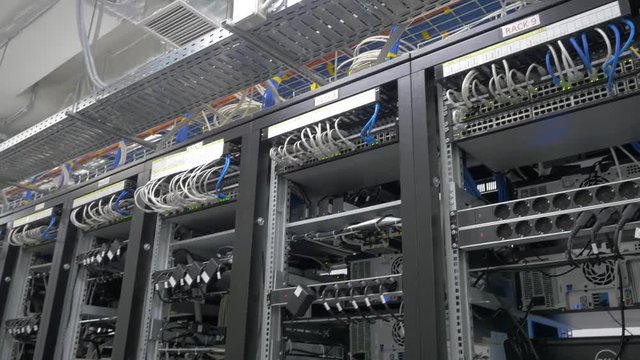 Device for mining crypto currency. Row of bitcoin miners set up on the wired shelfs. Mining cryptocurrency. Bitcoin farm. Machines for mining cryptocurrency, bitcoin. Electronic device at day