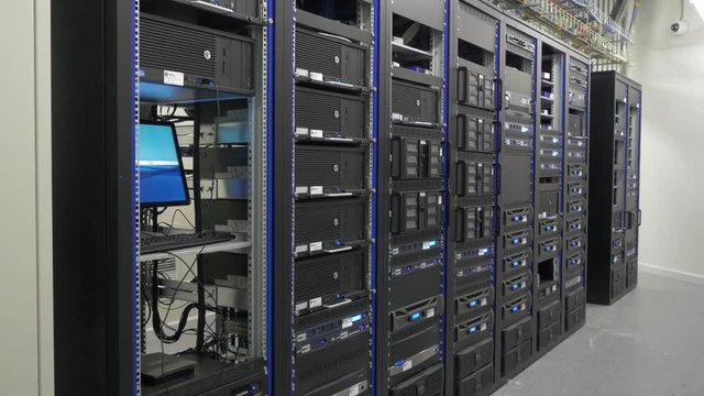 Many powerful servers running in the data center server room. Many servers in a data center. Many racks with servers located in the server room. Bright display a plurality of operating equipment.