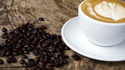 Cappuccino and latte art on the wood table. Free hand pouring some milk on the coffee. Morning breakfast with coffee.