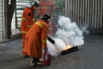 Instructor showing how to use a fire extinguisher. Gas tanks with fire. during training