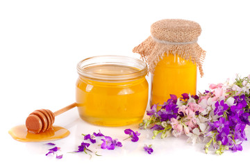 Jar of honey with wildflowers isolated on white background