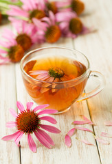 Cup of echinacea tea on white wooden table