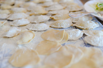Fototapeta na wymiar Closeup view of making traditional dumplings on kitchen table background