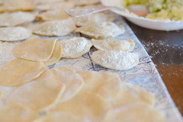Closeup view of making traditional dumplings on kitchen table background